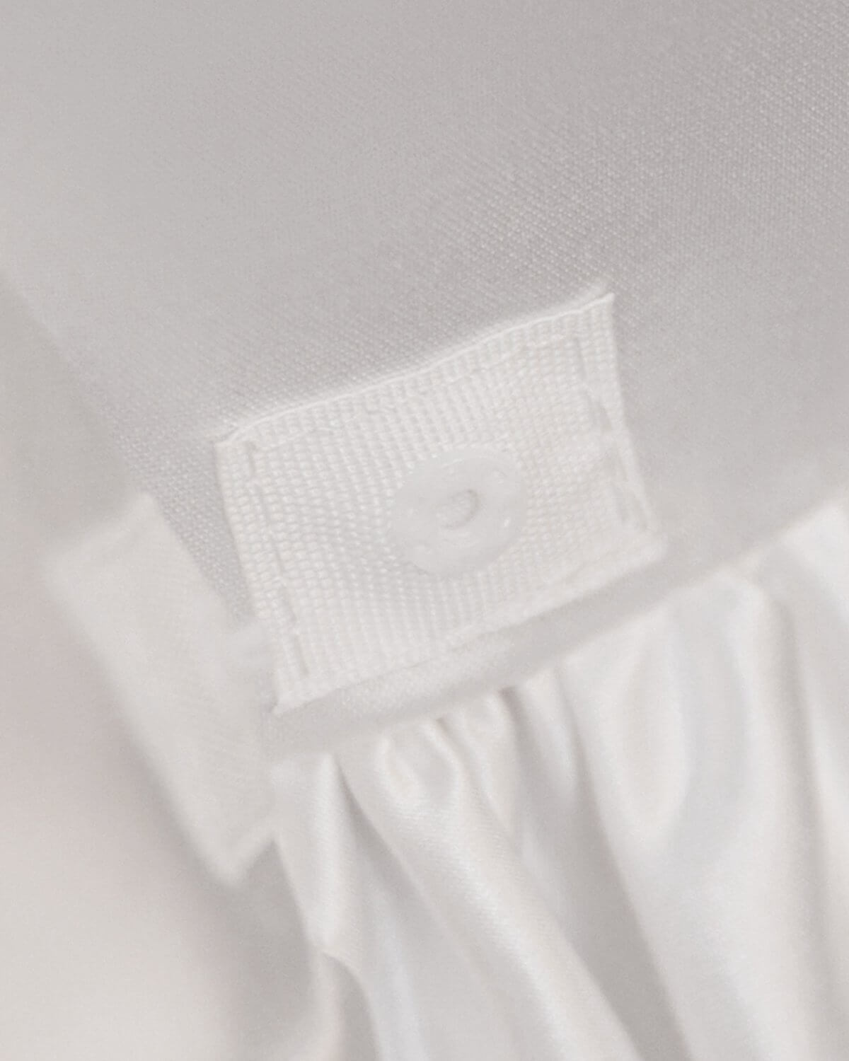 Fabric detail shot of premium ivory satin materials and hidden button closure on The Grace flower girl dress