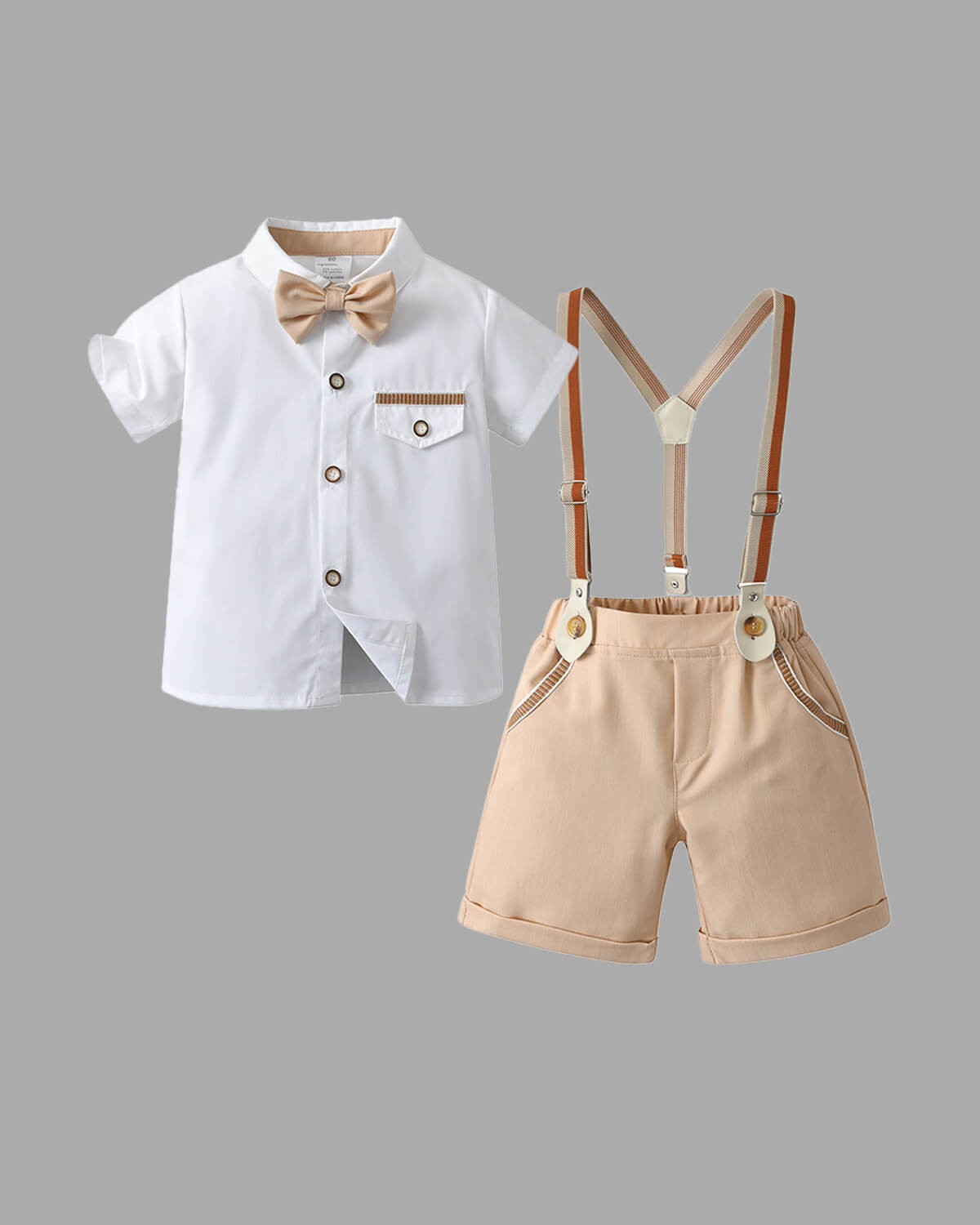Complete 4-piece boys summer wedding outfit flat lay including white short-sleeve dress shirt, beige shorts, vintage suspenders, and matching bowtie