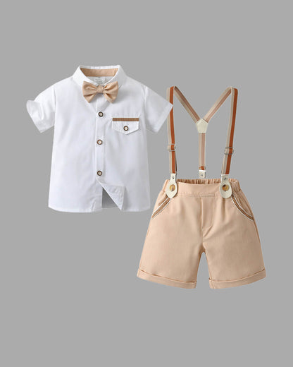 Complete 4-piece boys summer wedding outfit flat lay including white short-sleeve dress shirt, beige shorts, vintage suspenders, and matching bowtie