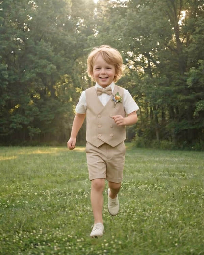 Happy little boy running freely in a green forest park, showcasing the comfort and breathability of the beige summer suit for kids.
