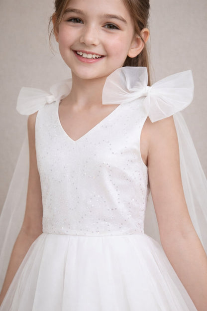 Close-up detail of the ivory white sequin bodice and delicate tulle shoulder bows on a high-quality girls wedding dress.
