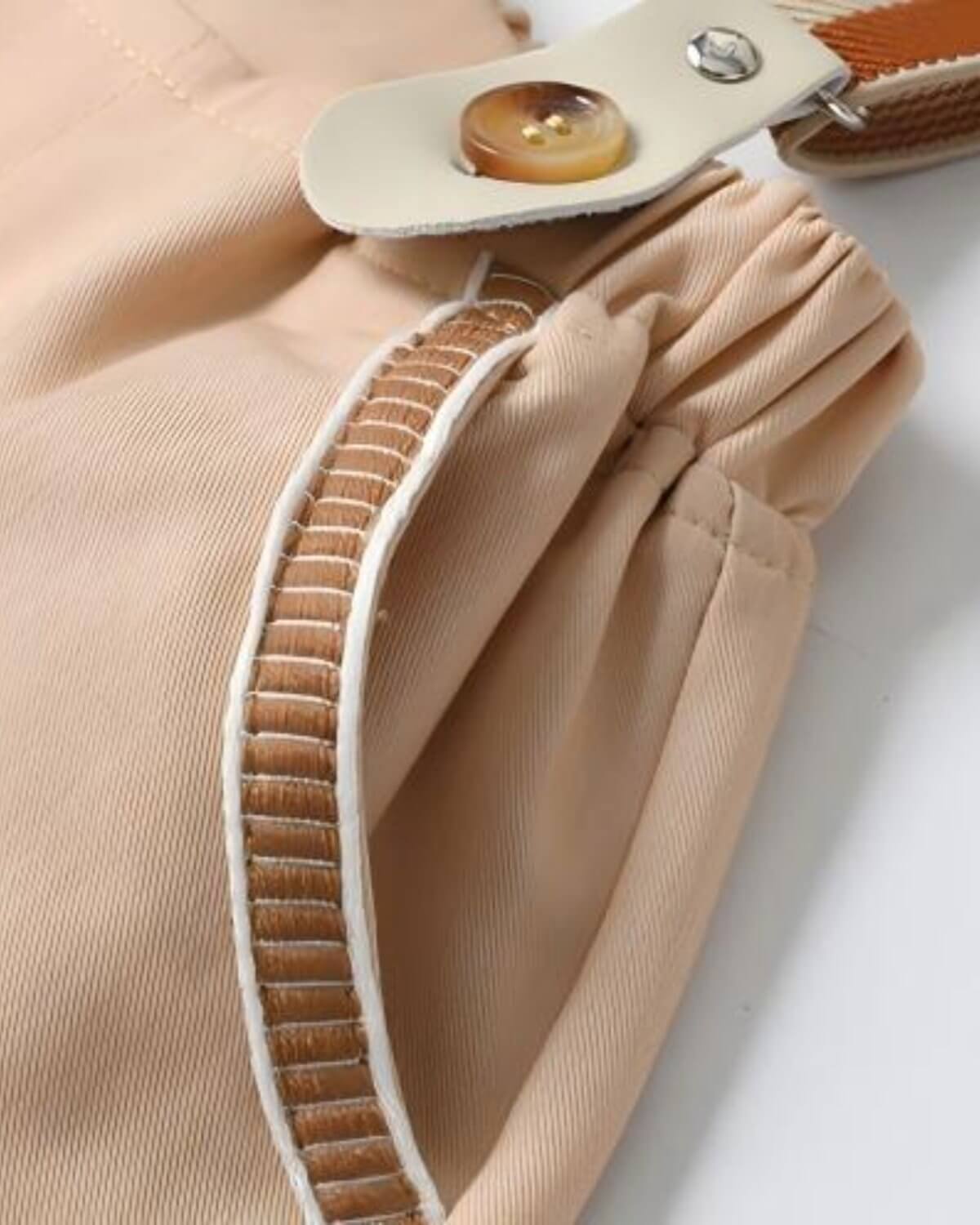 Detailed shot of boys khaki page boy shorts featuring a unique textured embroidered side pocket trim