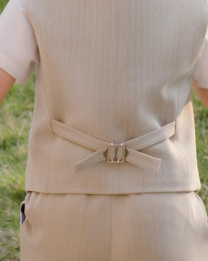 Back view detail of boys khaki linen formal vest showing the adjustable metal buckle strap and herringbone weave pattern