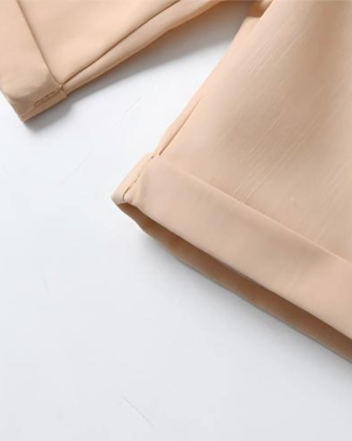 Close-up of boys beige formal shorts showing the clean, tailored cuffed hemline and premium summer fabric