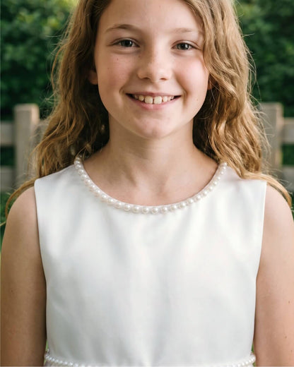 Close up front view of The Grace flower girl dress showing elegant pearl trim neckline and sleeveless satin bodice