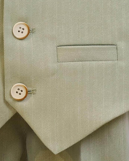 Macro shot of premium sage green herringbone fabric, featuring tailored faux pocket and vintage-style buttons.
