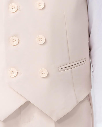 Macro close-up of the elegant 6-button layout and pocket welt detail on a boys oatmeal double-breasted waistcoat.