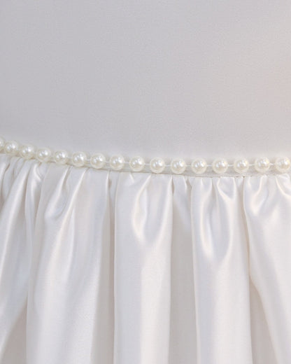 Detail shot of luxury pearl trim waistline and neat pleats on The Grace ivory satin flower girl dress