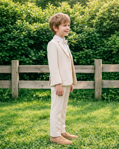 Side profile of a boy wearing a perfectly tailored beige formal suit for kids.