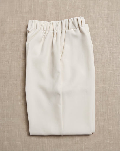 Little Ivory boy's formal beige cream wedding suit trousers waistband detail. Close-up showing the comfortable elastic waistband, crisp front crease, and soft cream linen fabric texture.