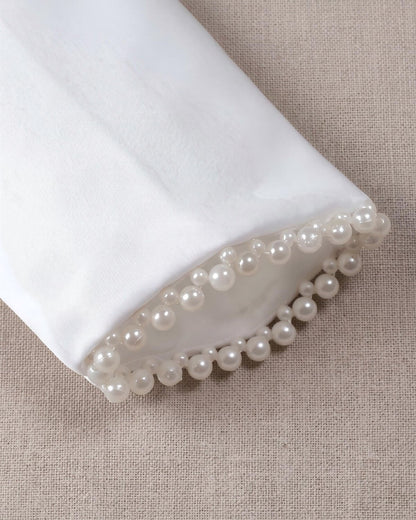 Detailed texture view of the long sleeve cuffs on the kids white satin bolero showing high-end double-row pearl bead embroidery details.