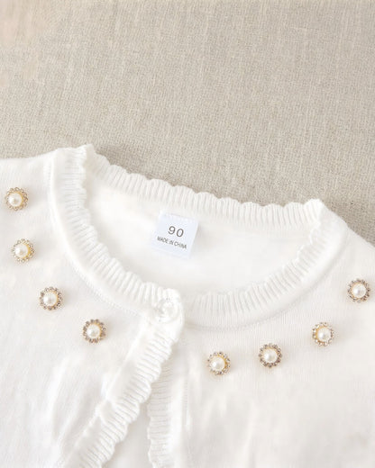 Close-up of the formal kids cardigan collar featuring luxury hand-placed rhinestone pearl halos, clear crystal button, and size 90 garment tag.